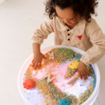 Lumi'sense Interactive Light-Up Sensory Table kid playing with sensory filling like play rice